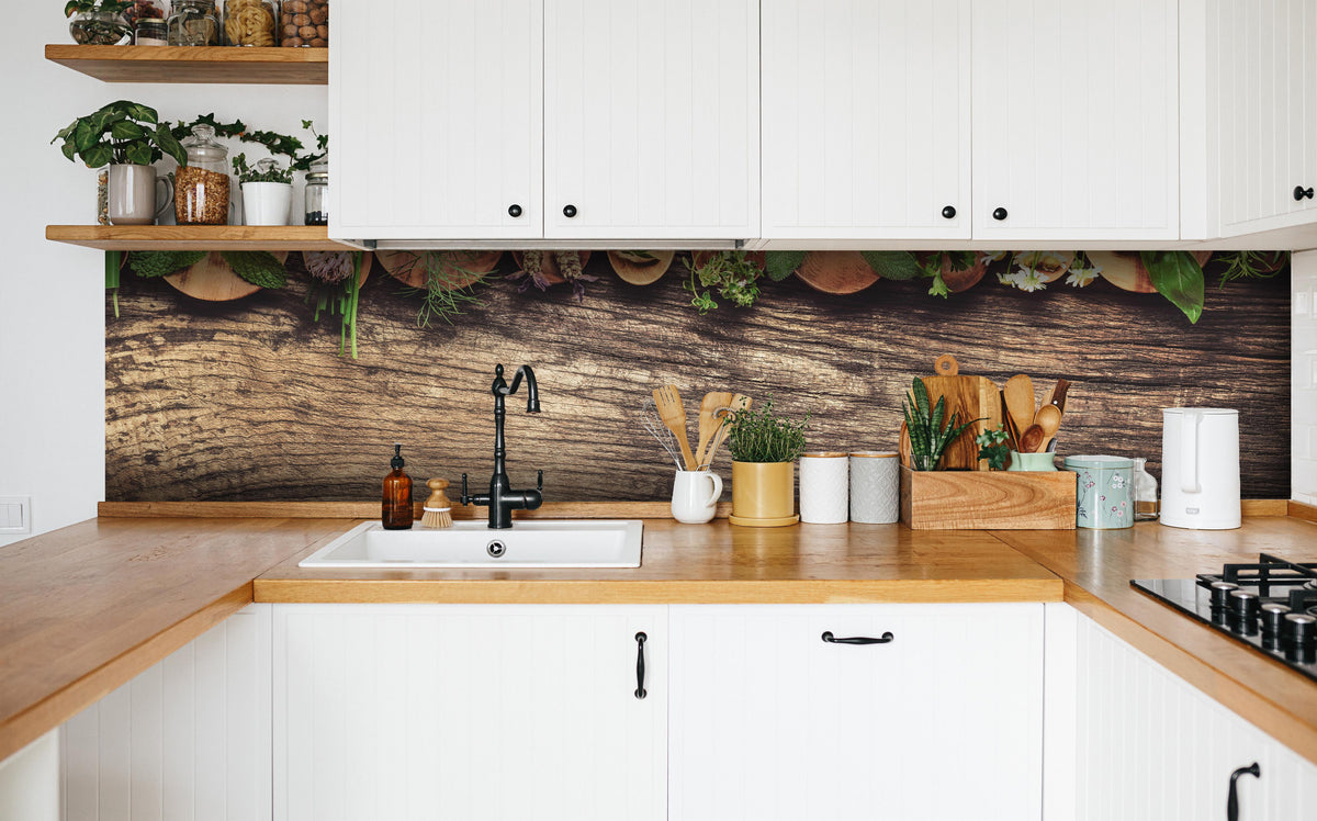 Küche - Frische Kräuter auf Holzplatte in weißer Küche hinter Gewürzen und Kochlöffeln aus Holz