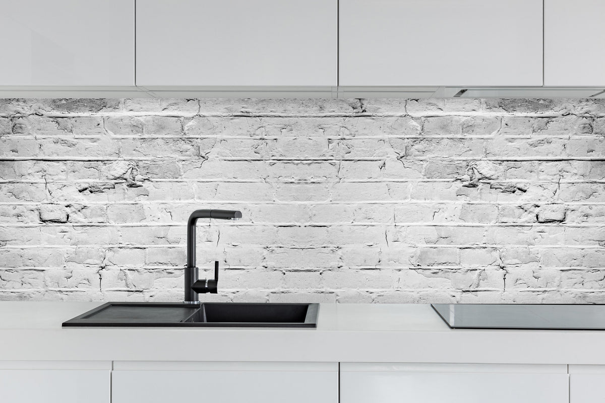 Küche - Weiß grau beschädigte Backstein Wand hinter weißen Hochglanz-Küchenregalen und schwarzem Wasserhahn