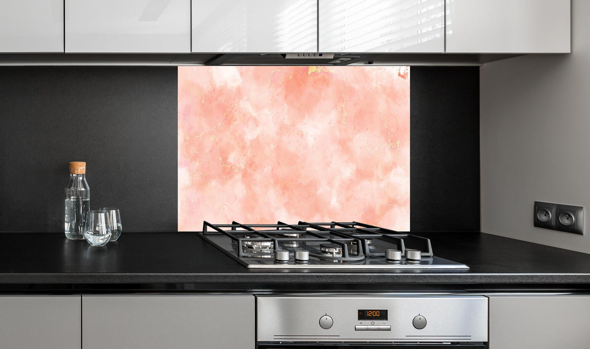 Spritzschutz - Eleganter Rosa-Gold Marmor Hintergrund hinter einem Cerankochfeld zwischen Holz-Kochutensilien