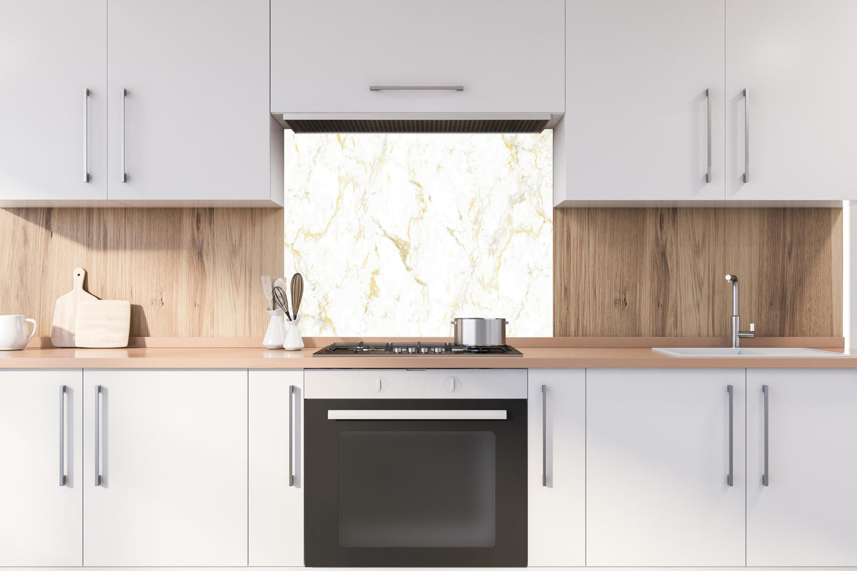 Spritzschutz - Goldmarmor Textur hinter einem Cerankochfeld zwischen Holz-Kochutensilien