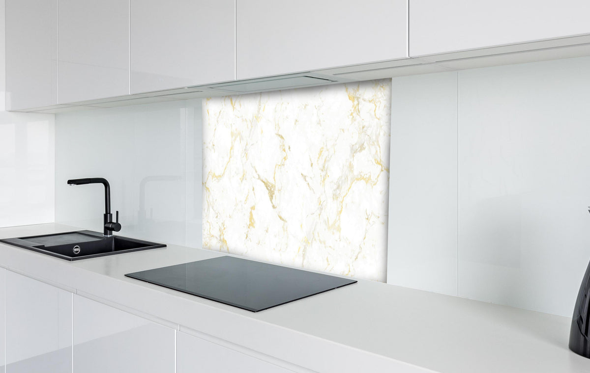 Spritzschutz - Goldmarmor Textur hinter einem Cerankochfeld zwischen Holz-Kochutensilien