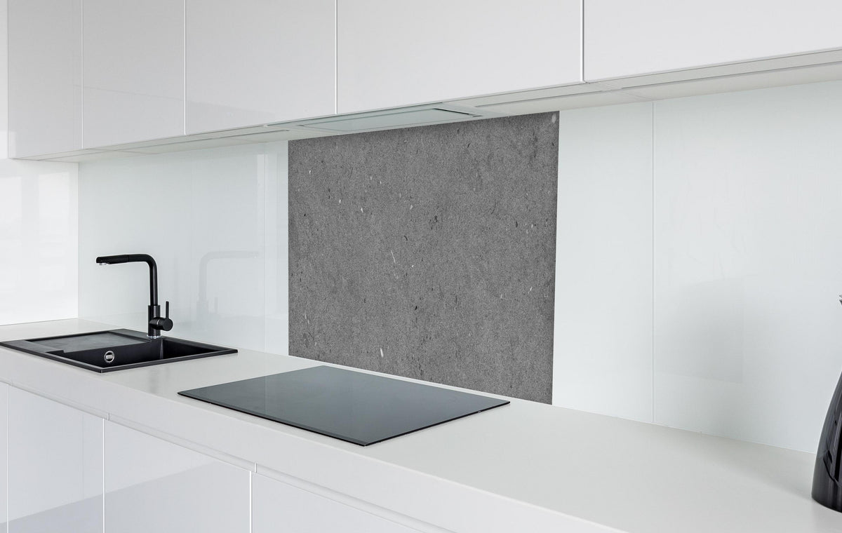 Spritzschutz - Grauer Marmor im Asphaltdesign in weißer Hochglanz-Küche hinter einem Cerankochfeld