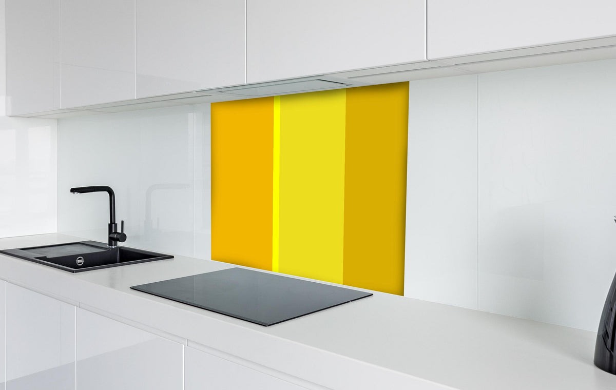 Spritzschutz - The Yellows - Vertical - Lemon hinter einem Cerankochfeld zwischen Holz-Kochutensilien