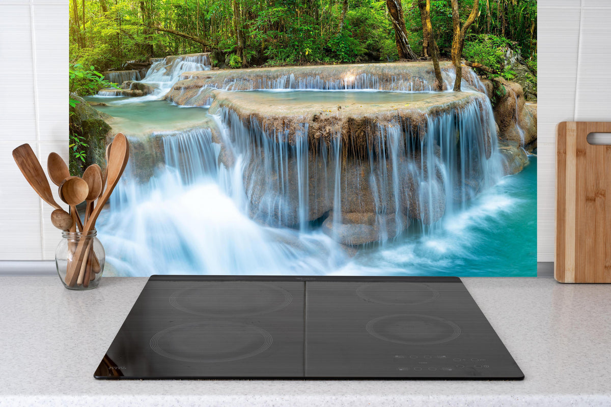 Küche - Wasserfall im Wald von Thailand hinter Cerankochfeld und Holz-Kochutensilien