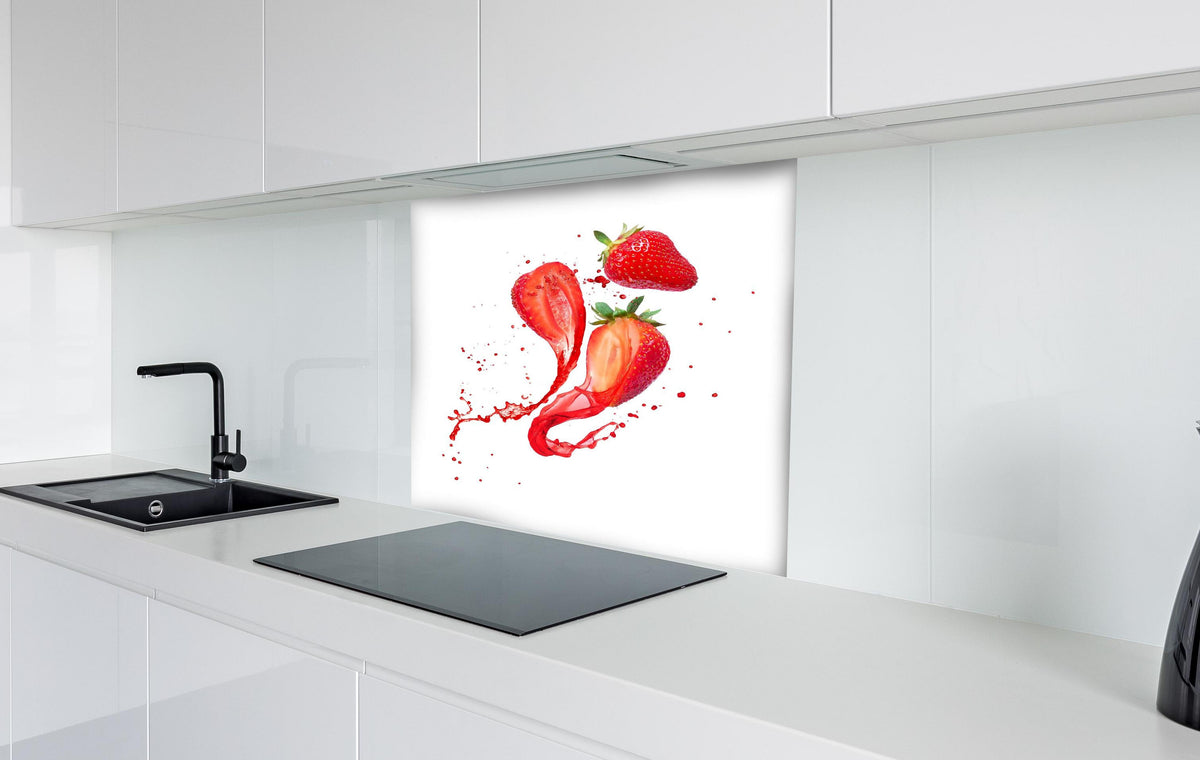Spritzschutz - Aufgeschnittene Erdbeeren auf weißem Hintergrund hinter einem Cerankochfeld zwischen Holz-Kochutensilien
