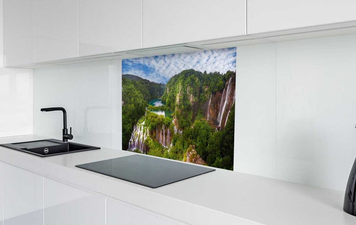 Spritzschutz - Multi-Wasserfall - Landschaft  in weißer Hochglanz-Küche hinter einem Cerankochfeld