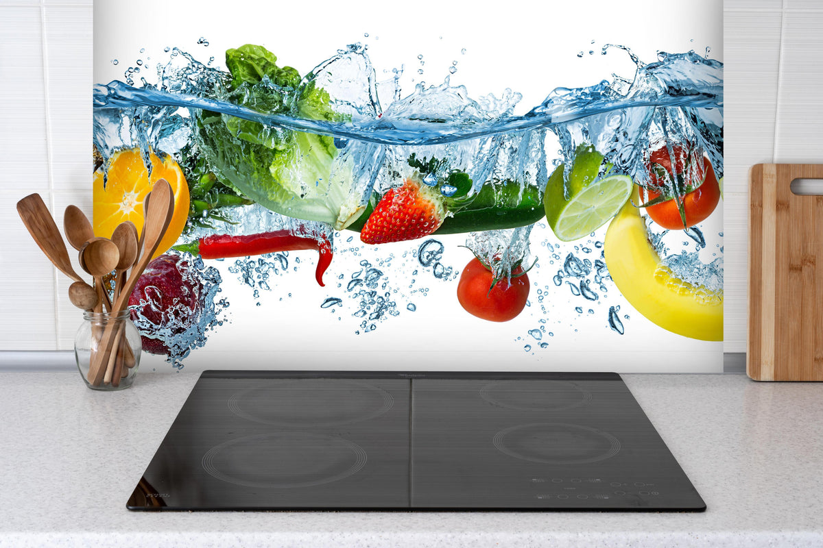 Spritzschutz - Obst & Gemüse im Wasser hinter einem Cerankochfeld zwischen Holz-Kochutensilien
