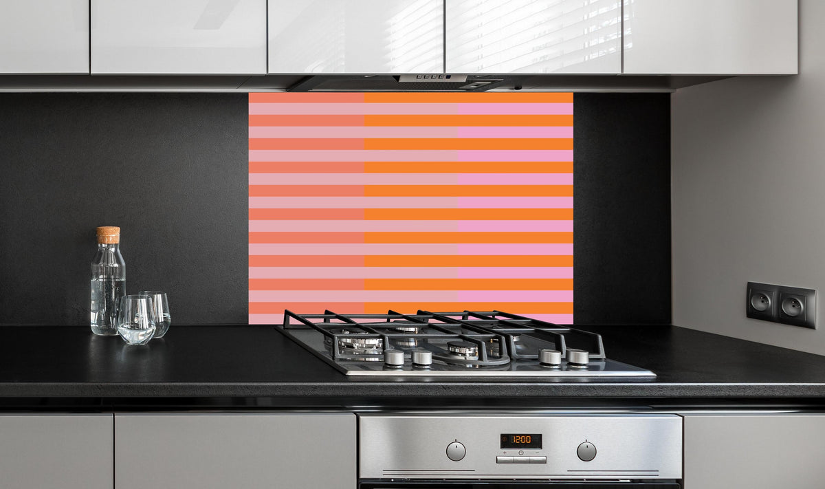 Spritzschutz - The Oranges - Multy Stripes - Coral hinter einem Cerankochfeld zwischen Holz-Kochutensilien
