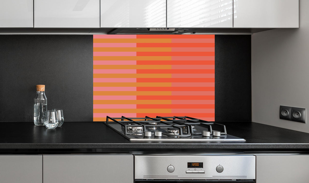 Spritzschutz - The Oranges - Multy Stripes - Salmon hinter einem Cerankochfeld zwischen Holz-Kochutensilien
